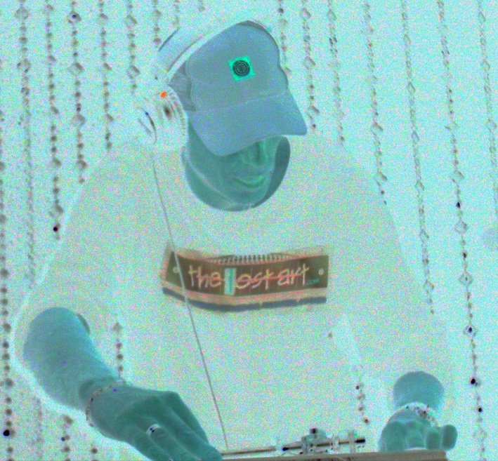 DJ Natural Nate® performing under cyan light wearing The-Lost-Art™ shirt